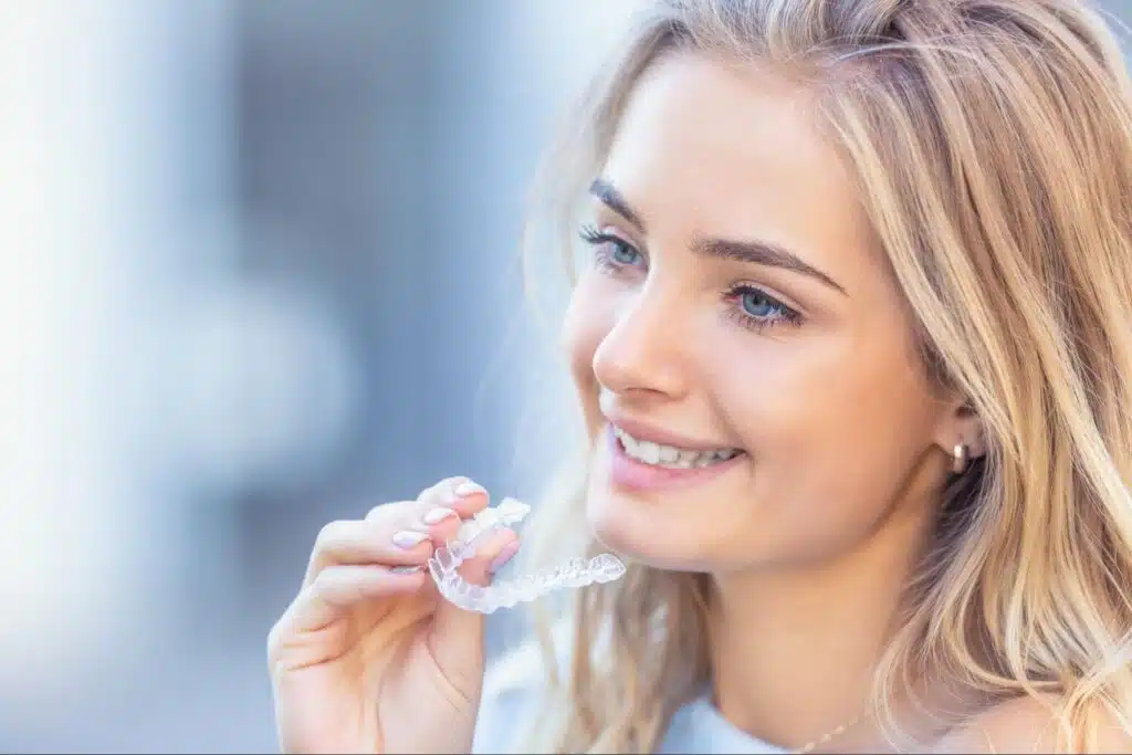 Patient holding Invisalign aligners